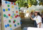 Kind zielt mit Pfeil auf die Ballonwand